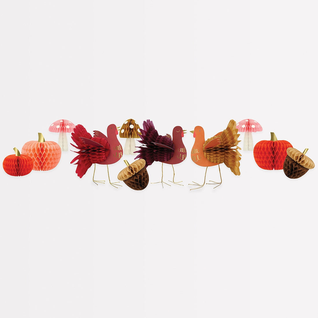 A variety of tissue paper honeycomb decorations with vintage designs including orange and peach pumpkins, mushrooms, acorns, and turkeys in shades of maroon and red.