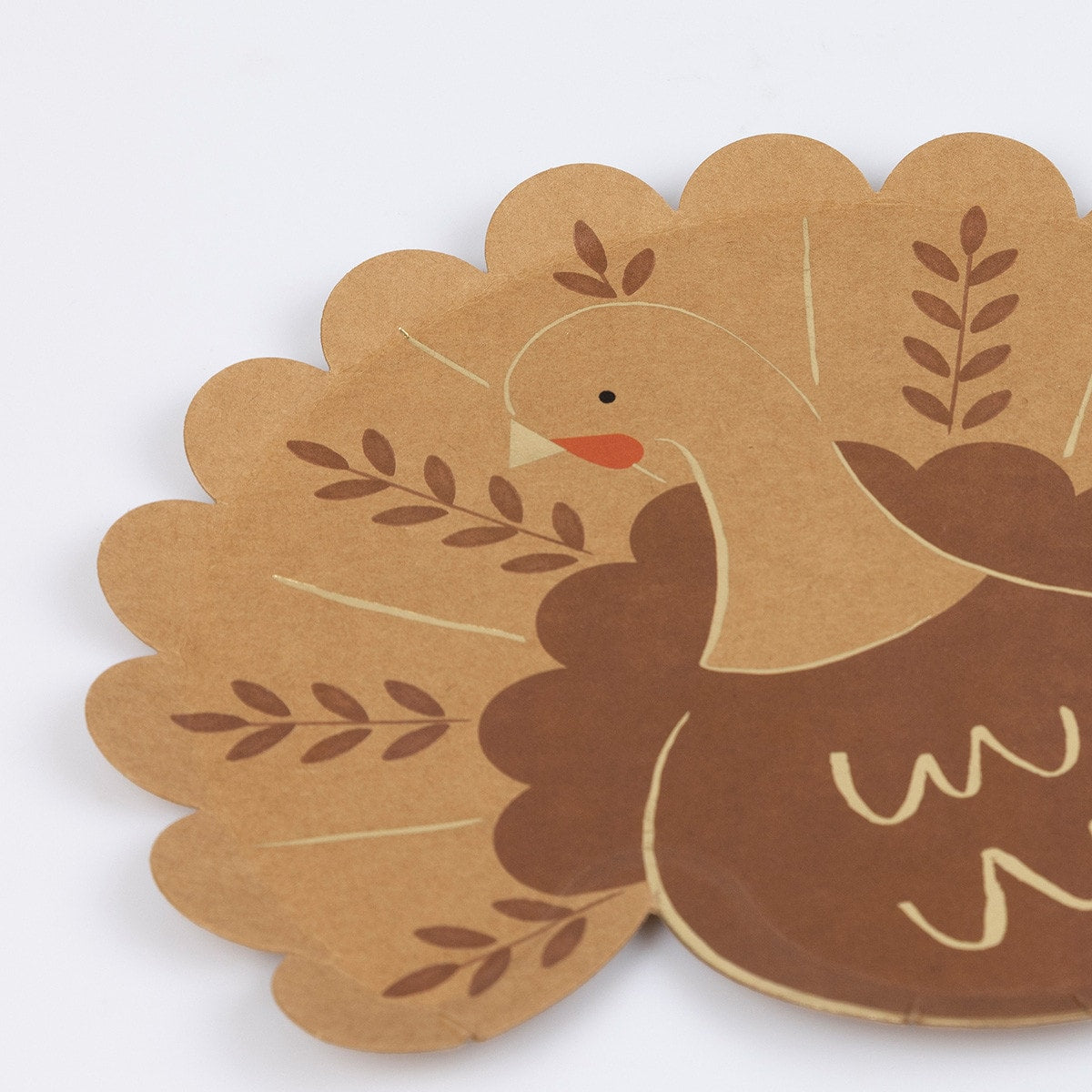 Paper plate shaped like a turkey with gold accents on a white background.