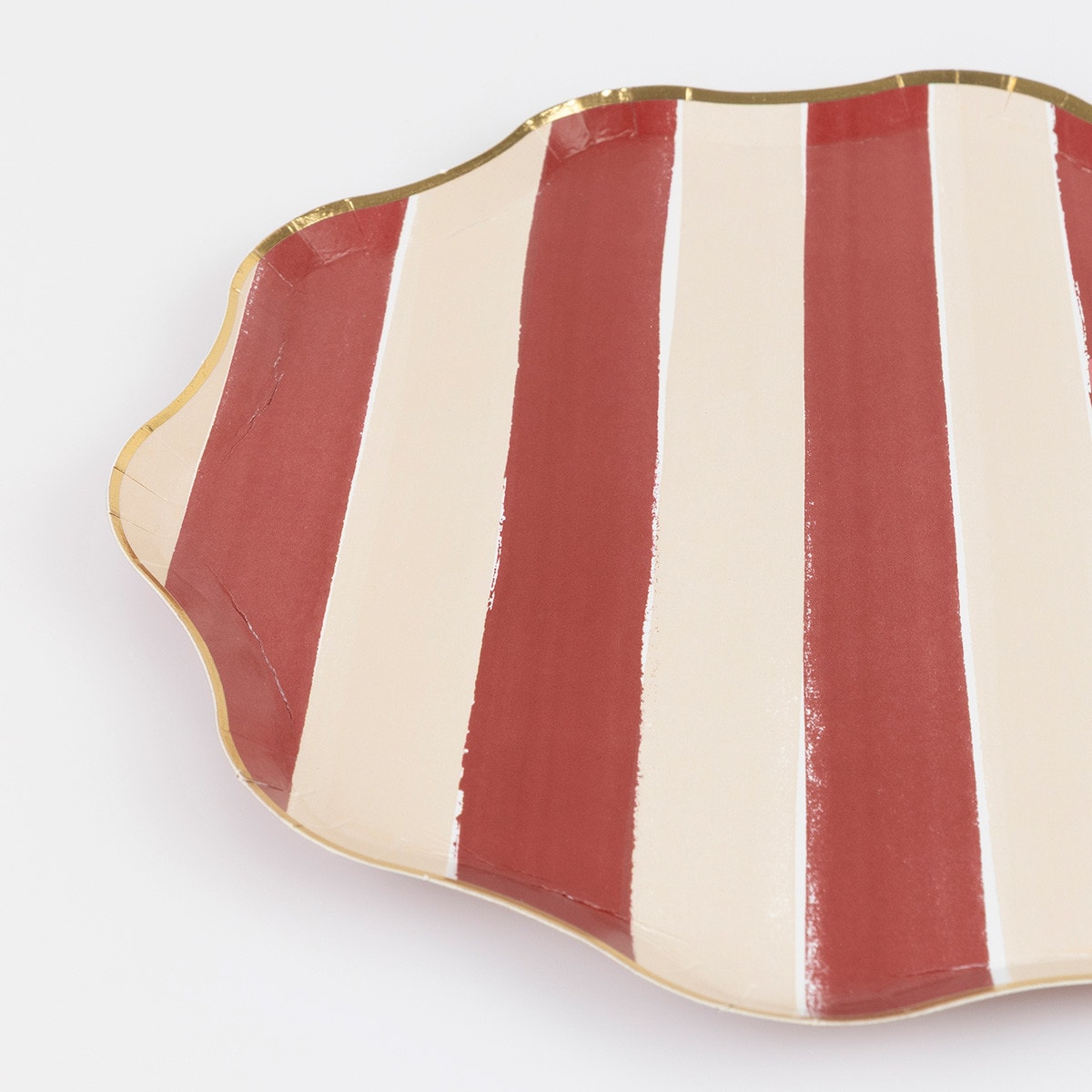 Red and white striped paper plate with gold rim on a white background. 