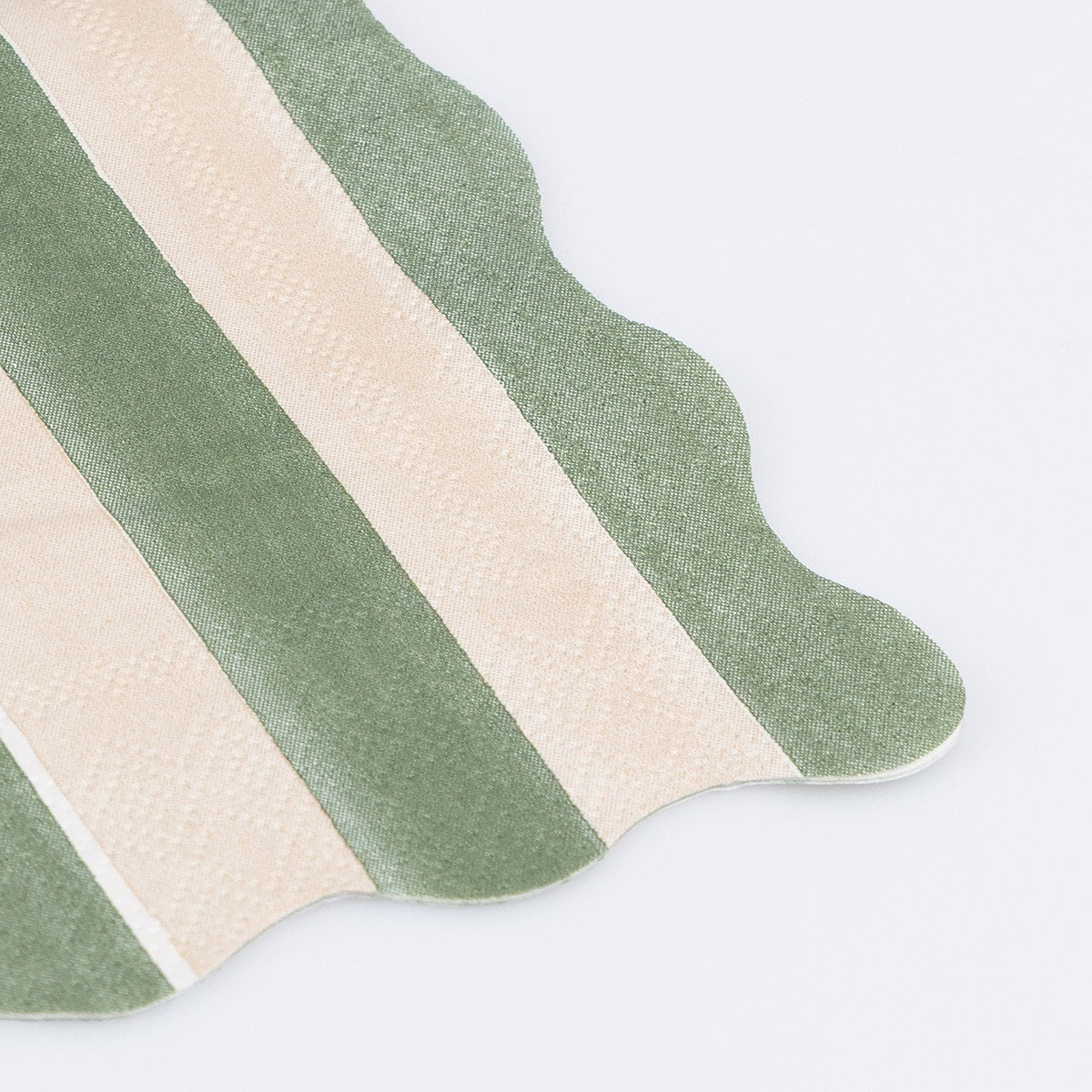 Green and white striped paper napkin with a scalloped edge. 
