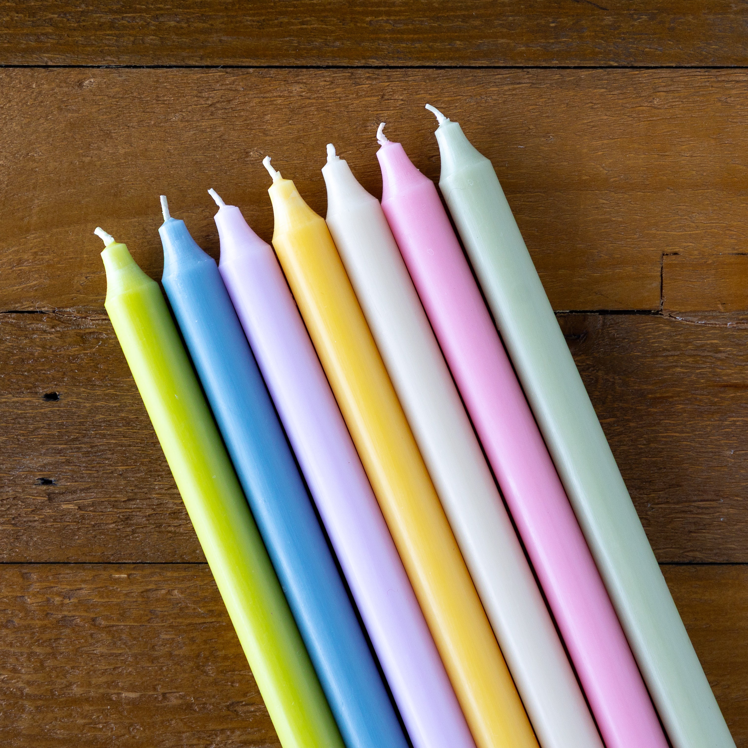 Set of colorful candles on a wooden surface.