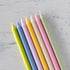 Set of pastel-colored candles on a marble surface.