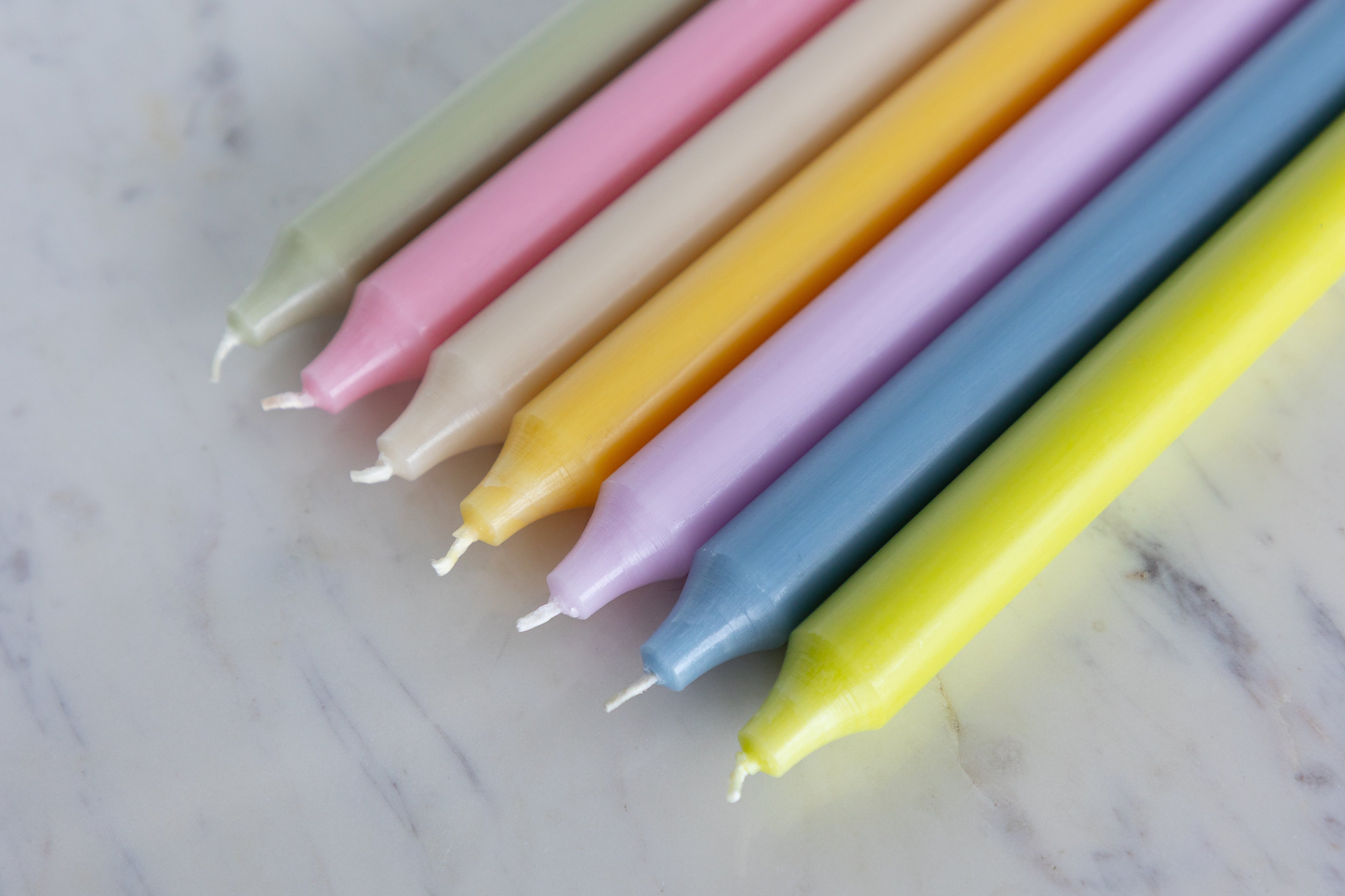 Set of colorful candles on a marble surface.