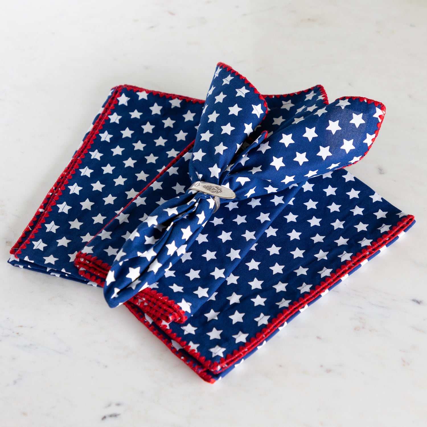 Set of blue and red patterned napkins on a marble surface.