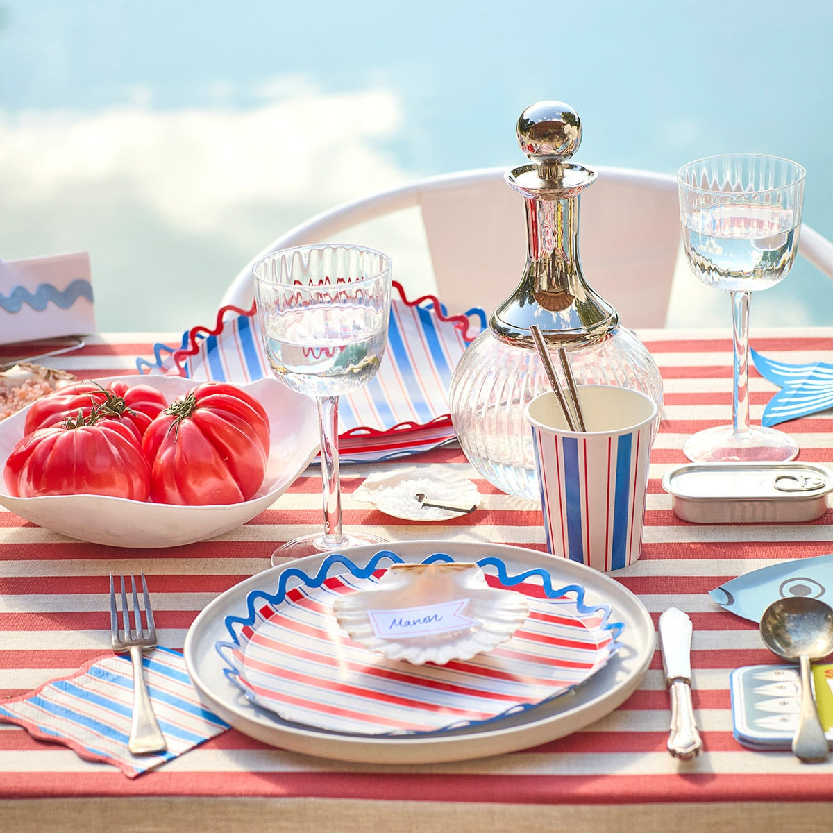 Dining table set with red, white, and blue theme outdoors.