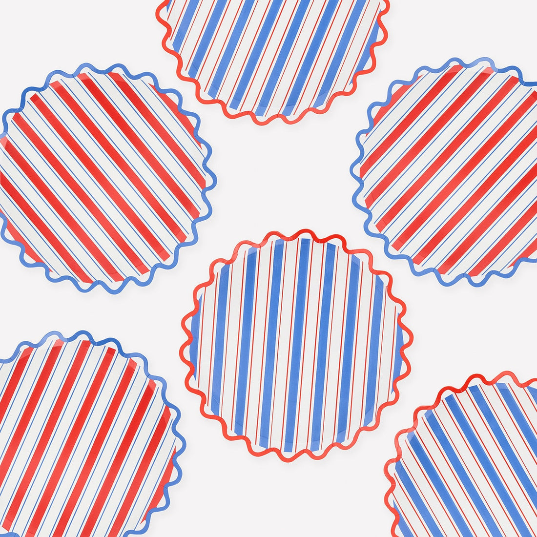 Pattern of red, white, and blue striped paper plates with scalloped edge on a white background.