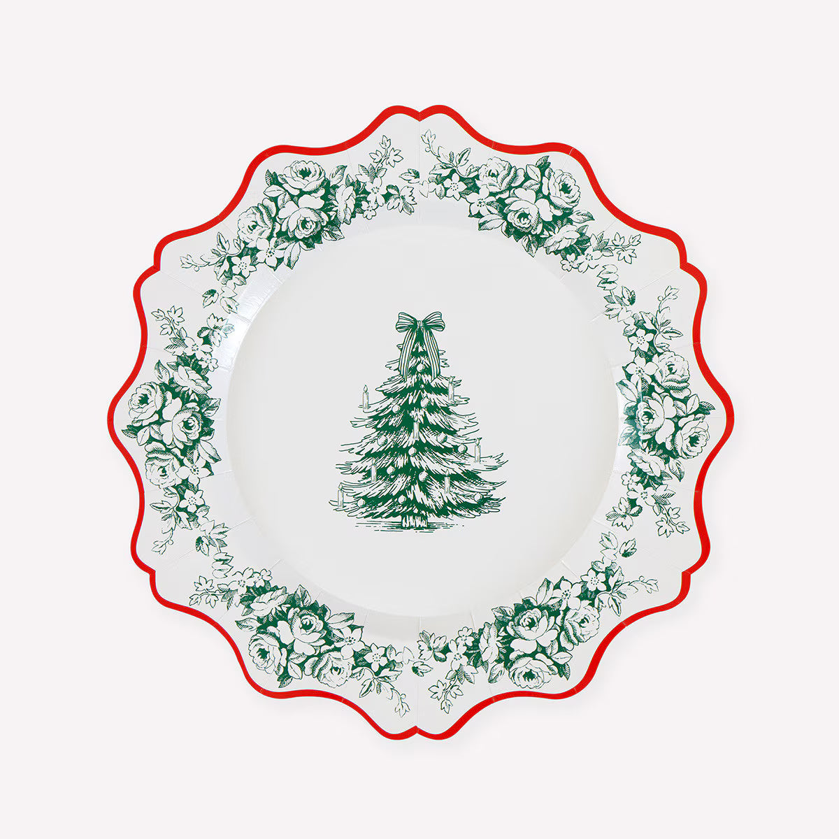 A white paper Christmas plate with a scalloped rim, featuring a green tree of life motif in the center and a border of green floral and holly patterns, accented by a red rim.