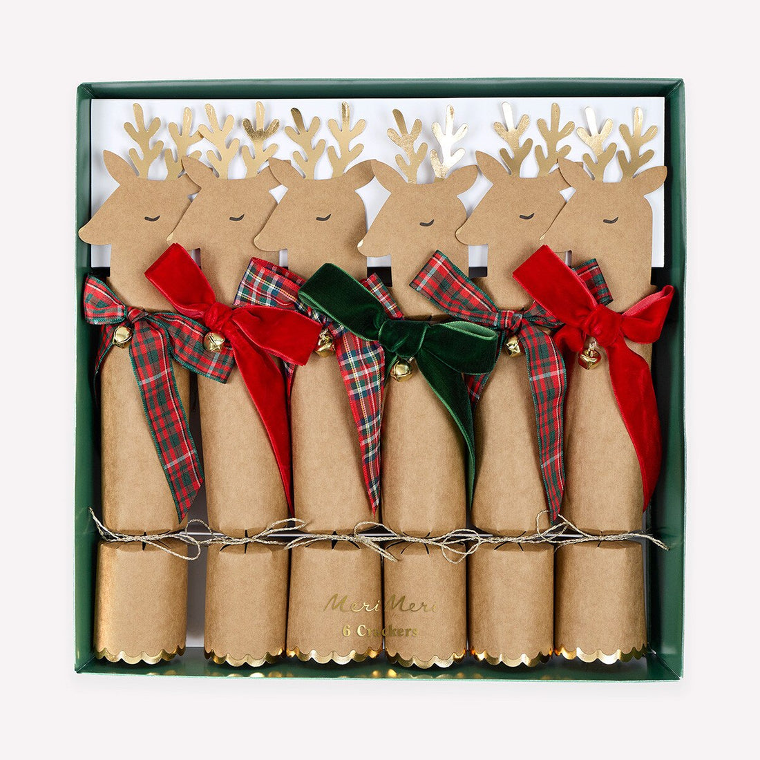 A set of five Christmas cracker ornaments in a dark green gift box. Each cracker is made of natural brown kraft paper, decorated with a reindeer head silhouette, gold antlers, and a ribbon bow in red plaid, red velvet, or green velvet.