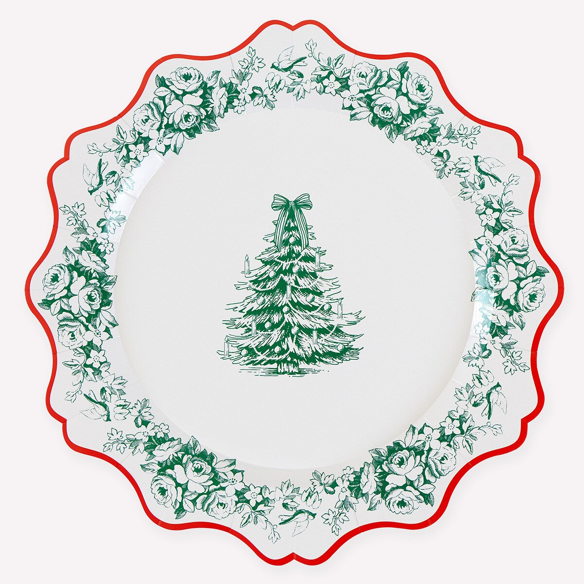 A scalloped paper plate with a green floral border and a green Christmas tree illustration in the center, set against a light off-white background.