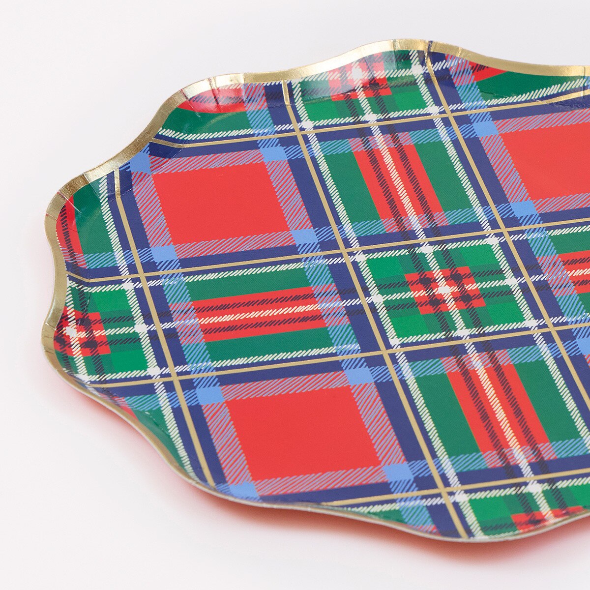 A scalloped paper plate with a festive red, green, and blue tartan plaid pattern and a metallic gold rim, shown on a plain white background.