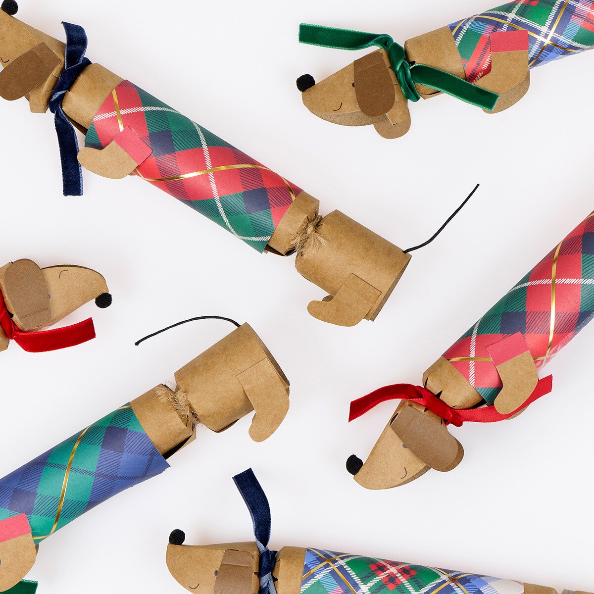 Dog-shaped Christmas crackers with plaid patterns on a white background