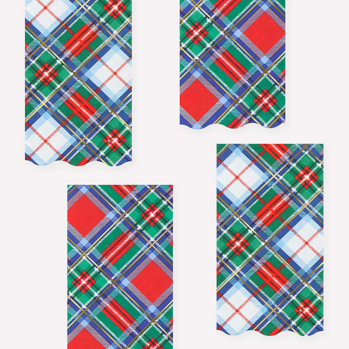 Four rectangular fabric napkins with scalloped edges featuring a festive Christmas tartan plaid pattern in red, green, blue, white, and yellow, arranged on a light gray background.