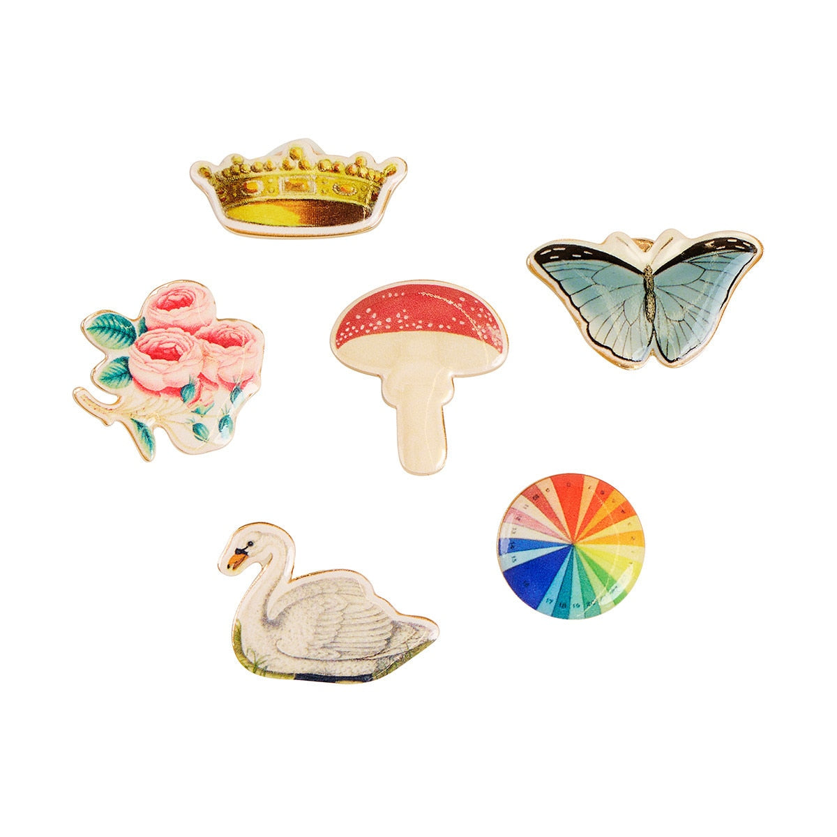 Set of colorful pins including a crown, mushroom, butterfly, swan, and rainbow design on a white background.