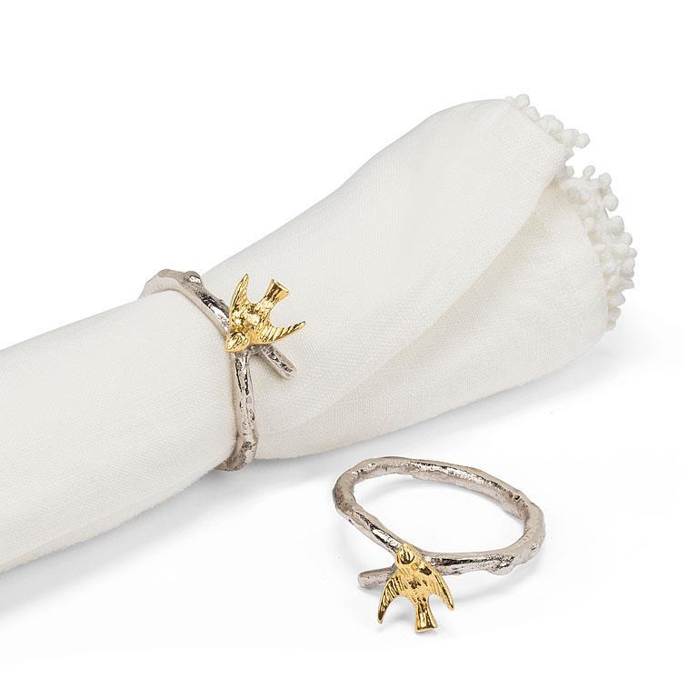 Decorative bird-themed napkin rings on a white napkin with a white background.