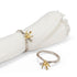 Decorative bird-themed napkin rings on a white napkin with a white background.