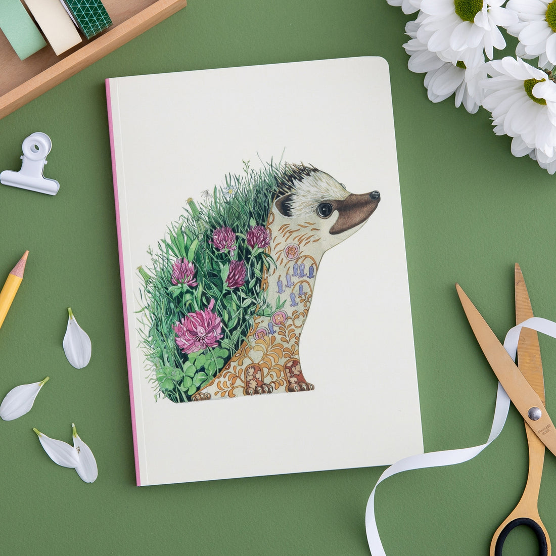 A Hedgehog Perfect Bound Notebook with a hedgehog and flowers on it, crafted by The DM Collection on luxury cream stock.