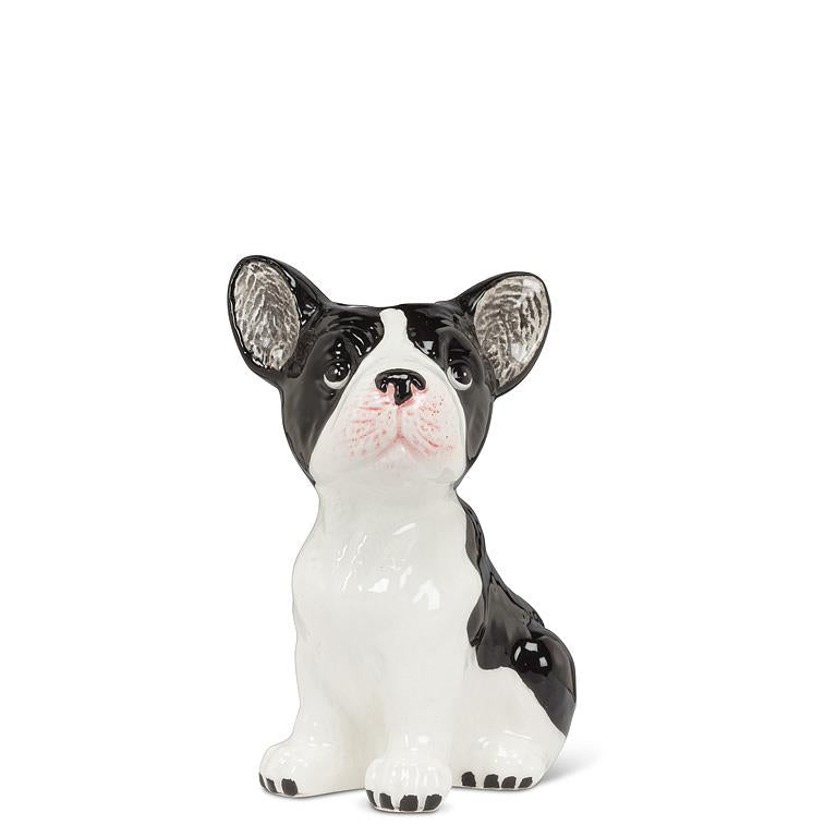 Ceramic figurine of a black and white dog on a white background.