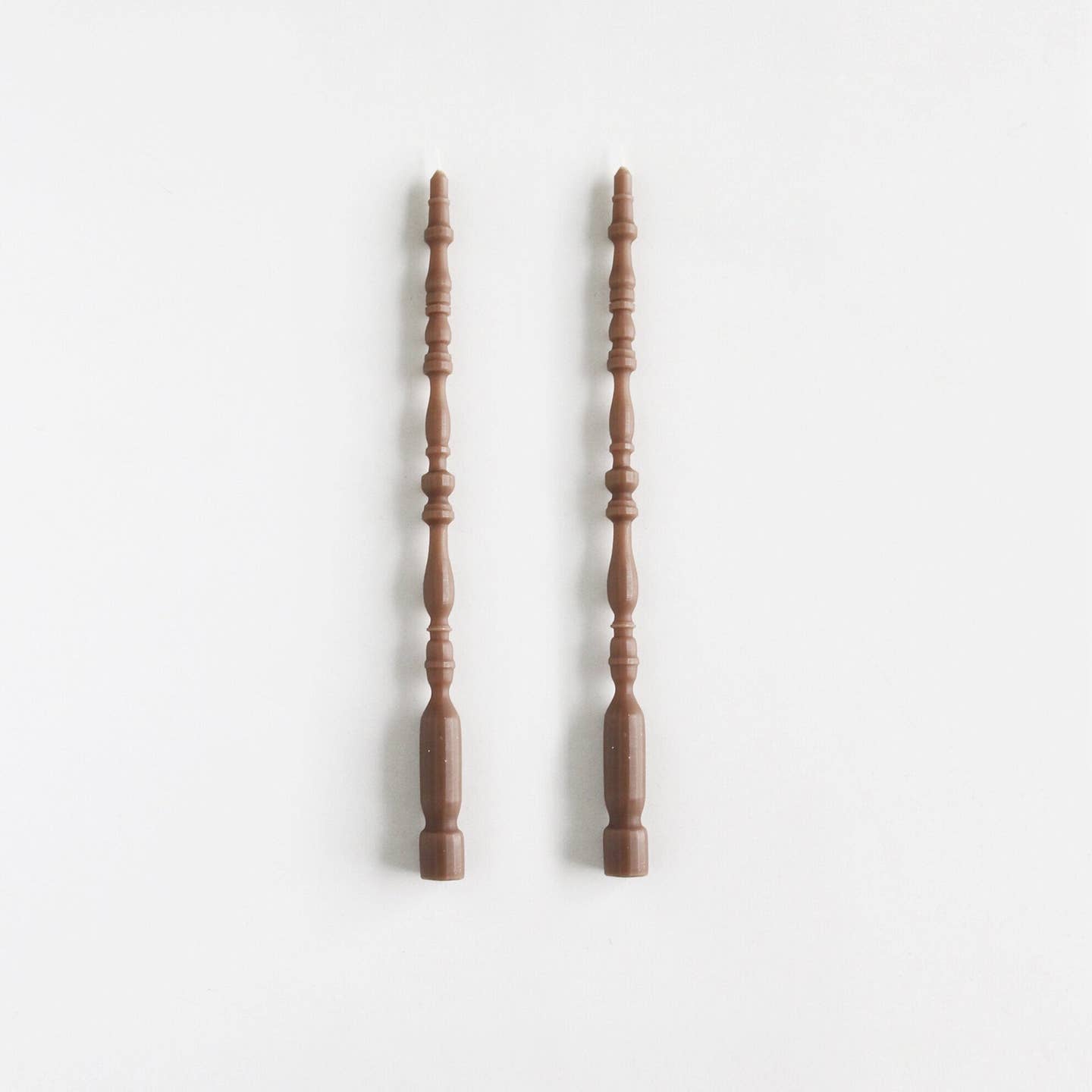 2 taper candles shaped like table spindle legs in fawn. 