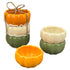 Set of ceramic pumpkin-shaped ramekins in orange, green, and white on a white background.