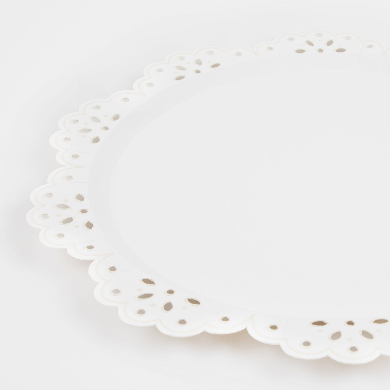 White doily paper plate with scalloped edge on a white background