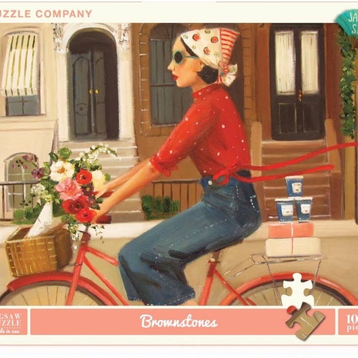 A Brownstones Puzzle of a woman riding a red bicycle with a basket of flowers in front of a building with windows and doors, crafted by Janet Hill, by New York Puzzle Company.