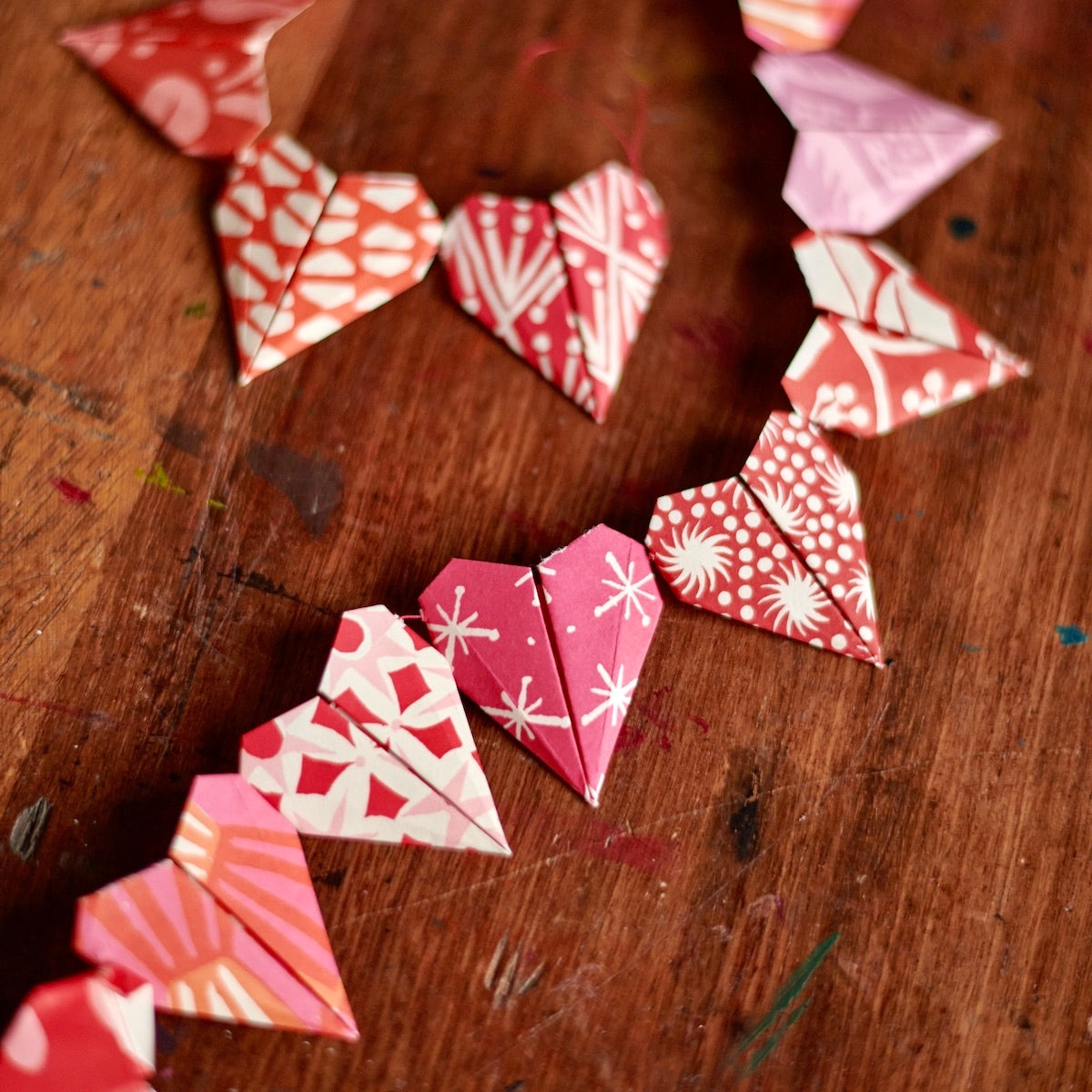 Red and pink origami hearts being crafted. 