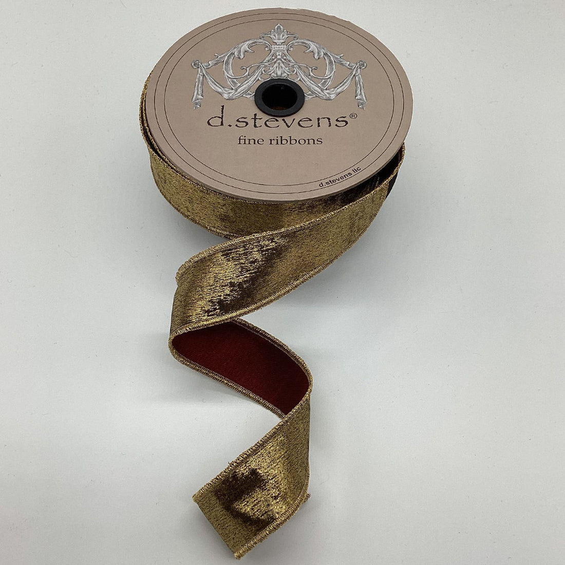 A spool of brushed metallic antique burgundy/gold ribbon, with the d.stevens brand visible on the top.