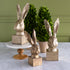 Decorative rabbit head sculptures on stands with a green wall background.