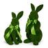 Two green decorative bunnies with green ribbons, one sitting and one on its hind legs, on a white background.