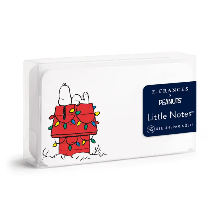 E. Frances x Peanuts Little Notes desk pad with a white cover featuring Snoopy on a red doghouse with Christmas lights, and a navy blue brand label.