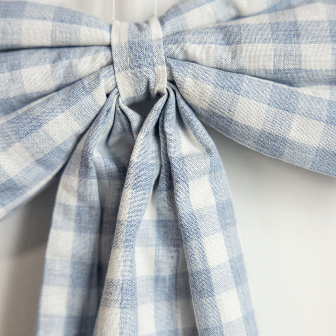 Blue and white checkered bow on a light background