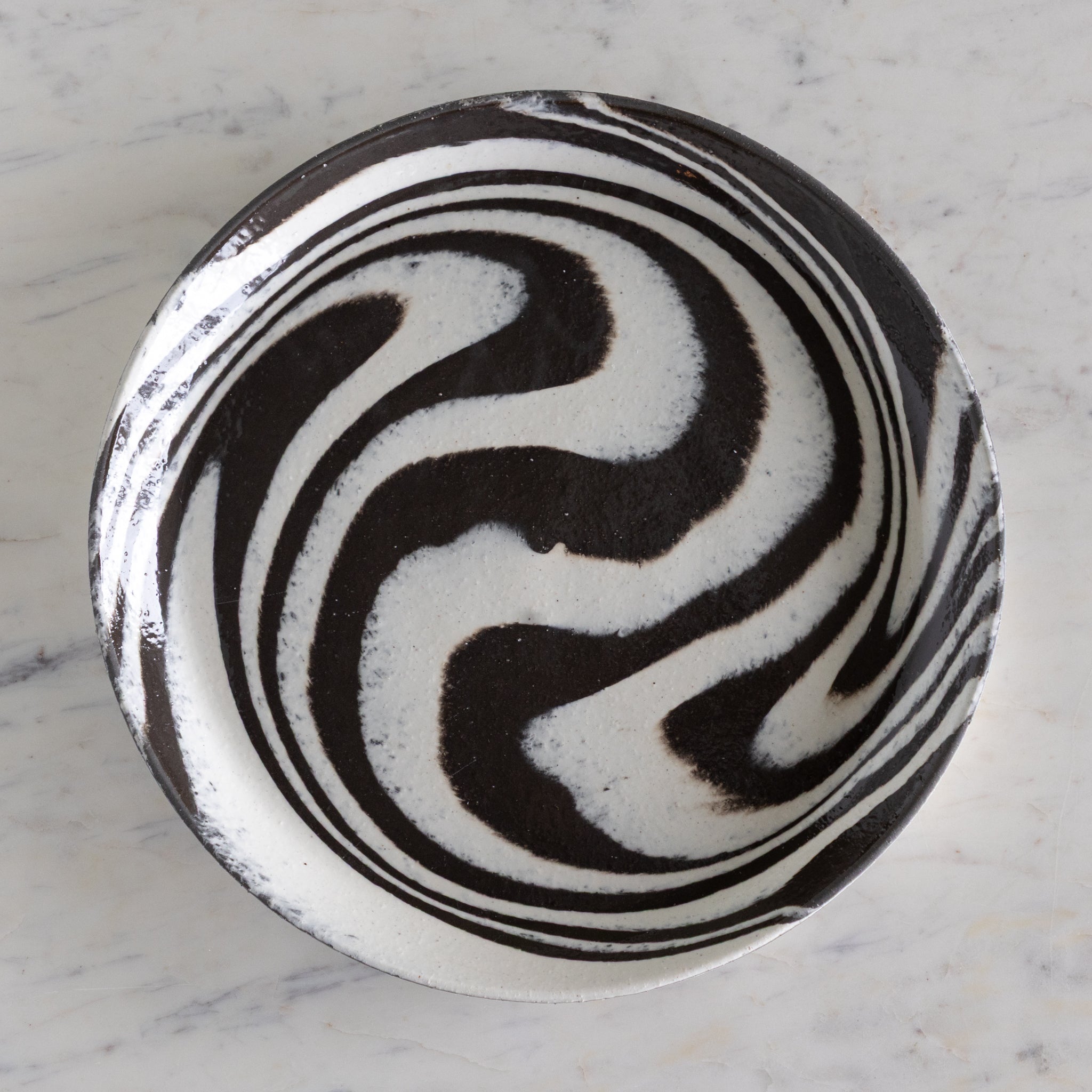 Black and white marbled pattern on a ceramic plate.