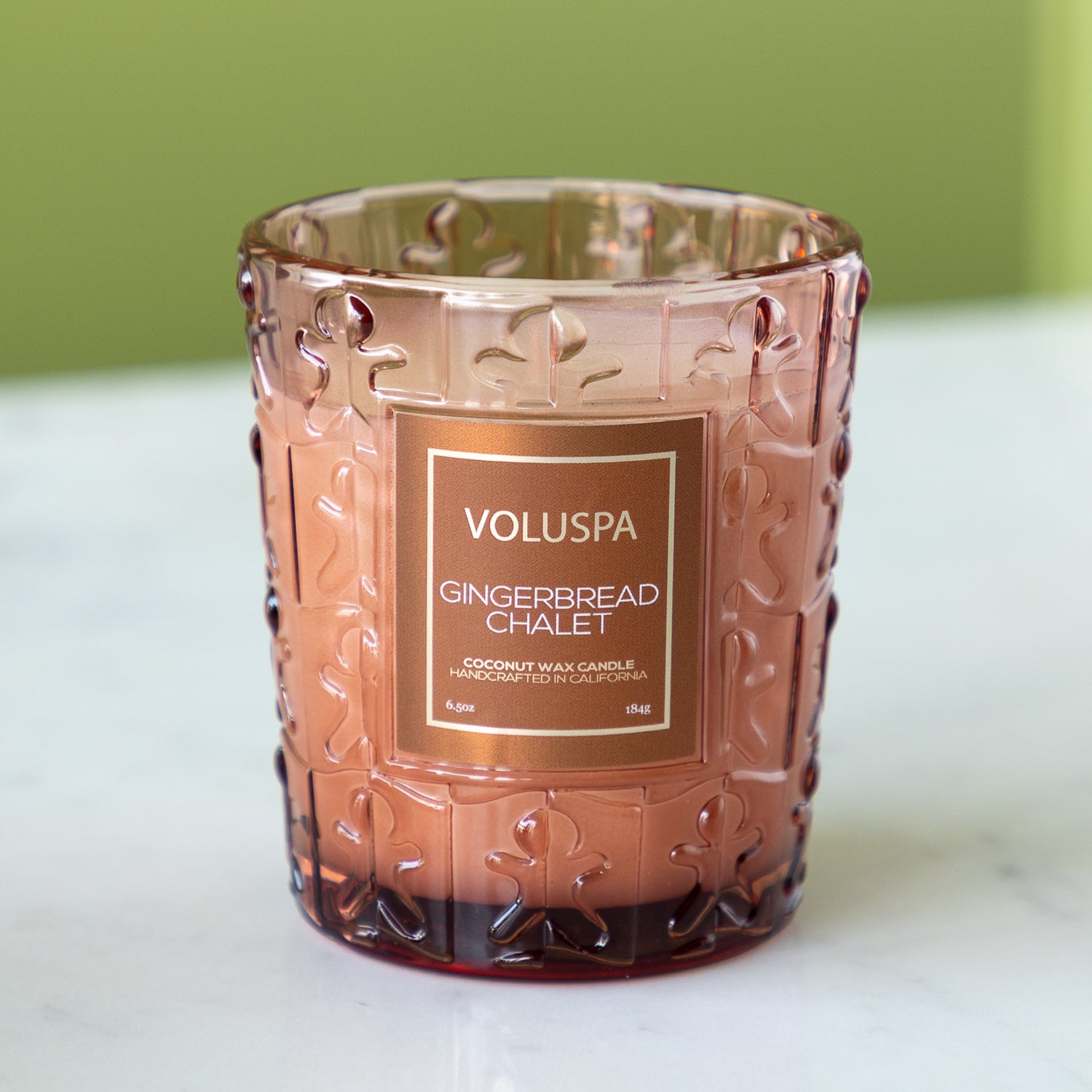 Decorative candle with Voluspa label on a white surface.