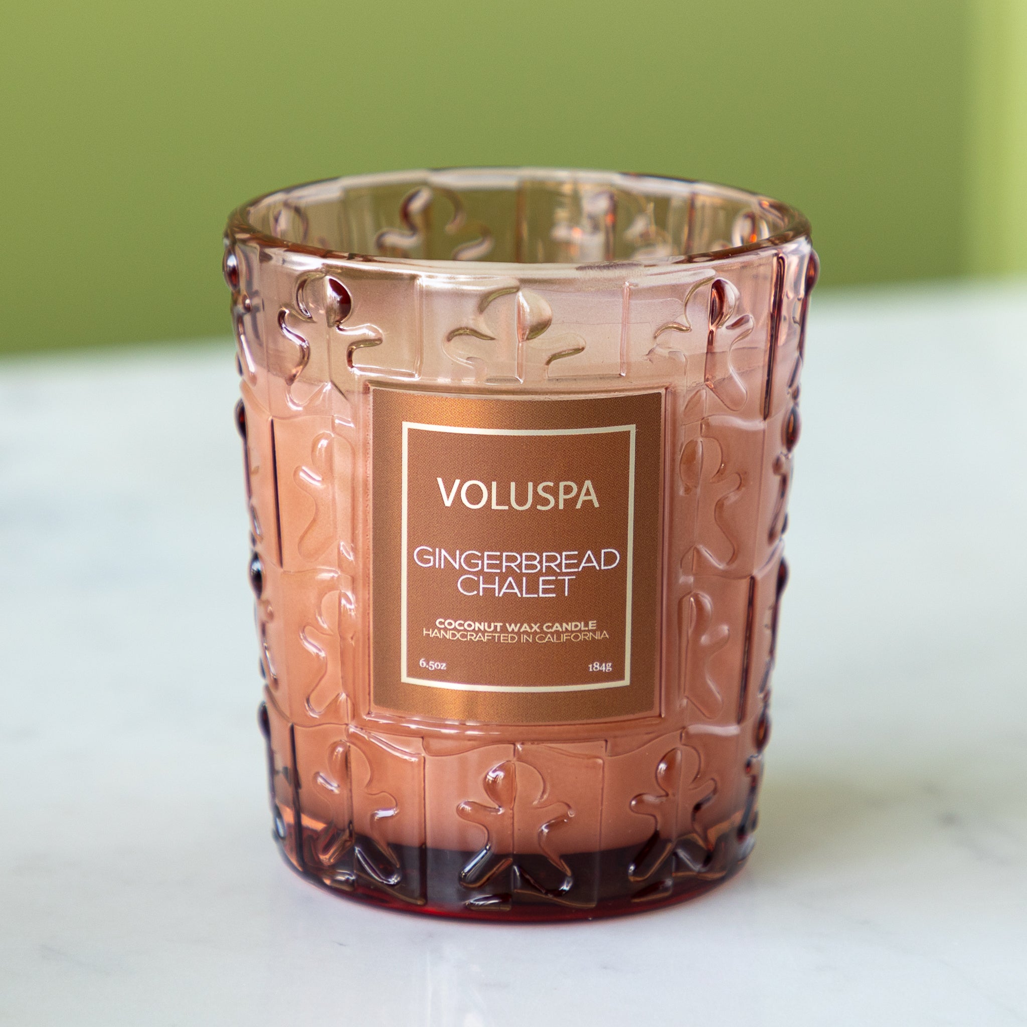 Decorative candle with Voluspa label on a white surface.