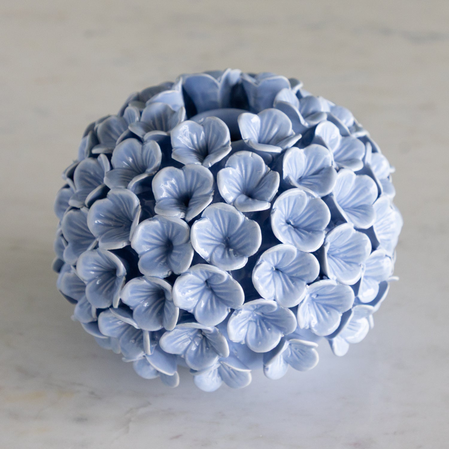 Ceramic vase with blue floral pattern on a light gray background.