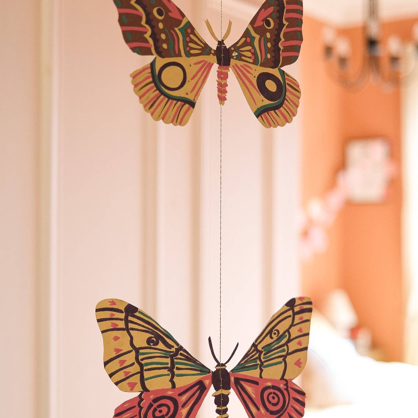 Colorful butterfly-shaped garland against a blurred indoor background.