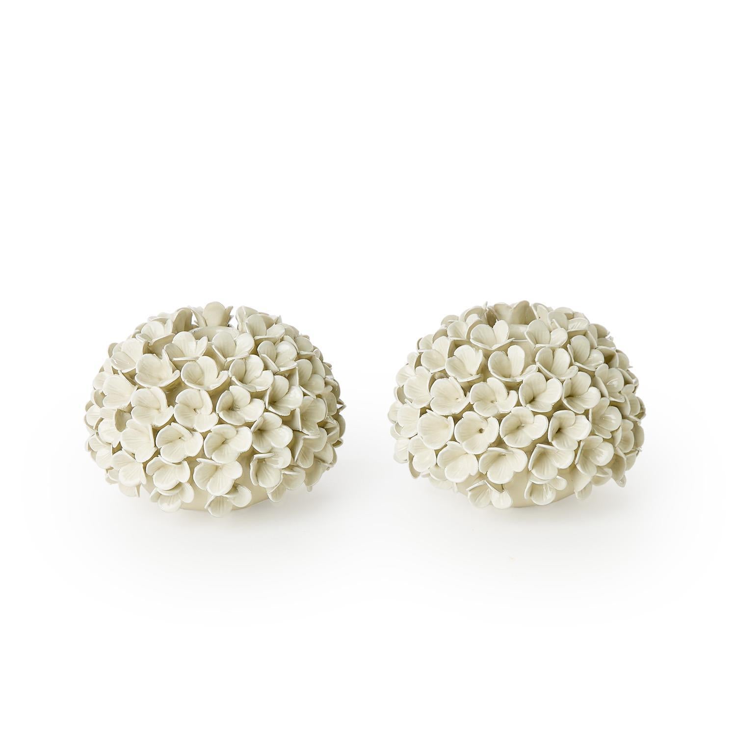 Pair of white floral ceramic balls on a white background