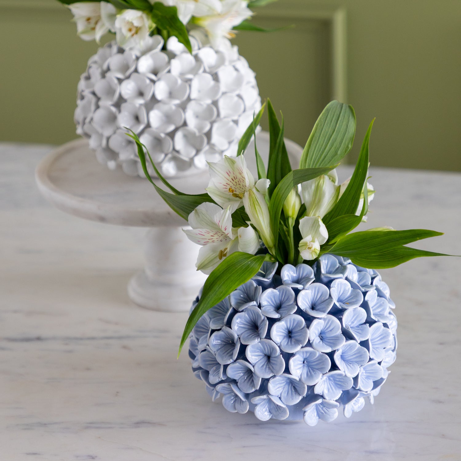 Decorative vase with floral arrangement on a marble surface.