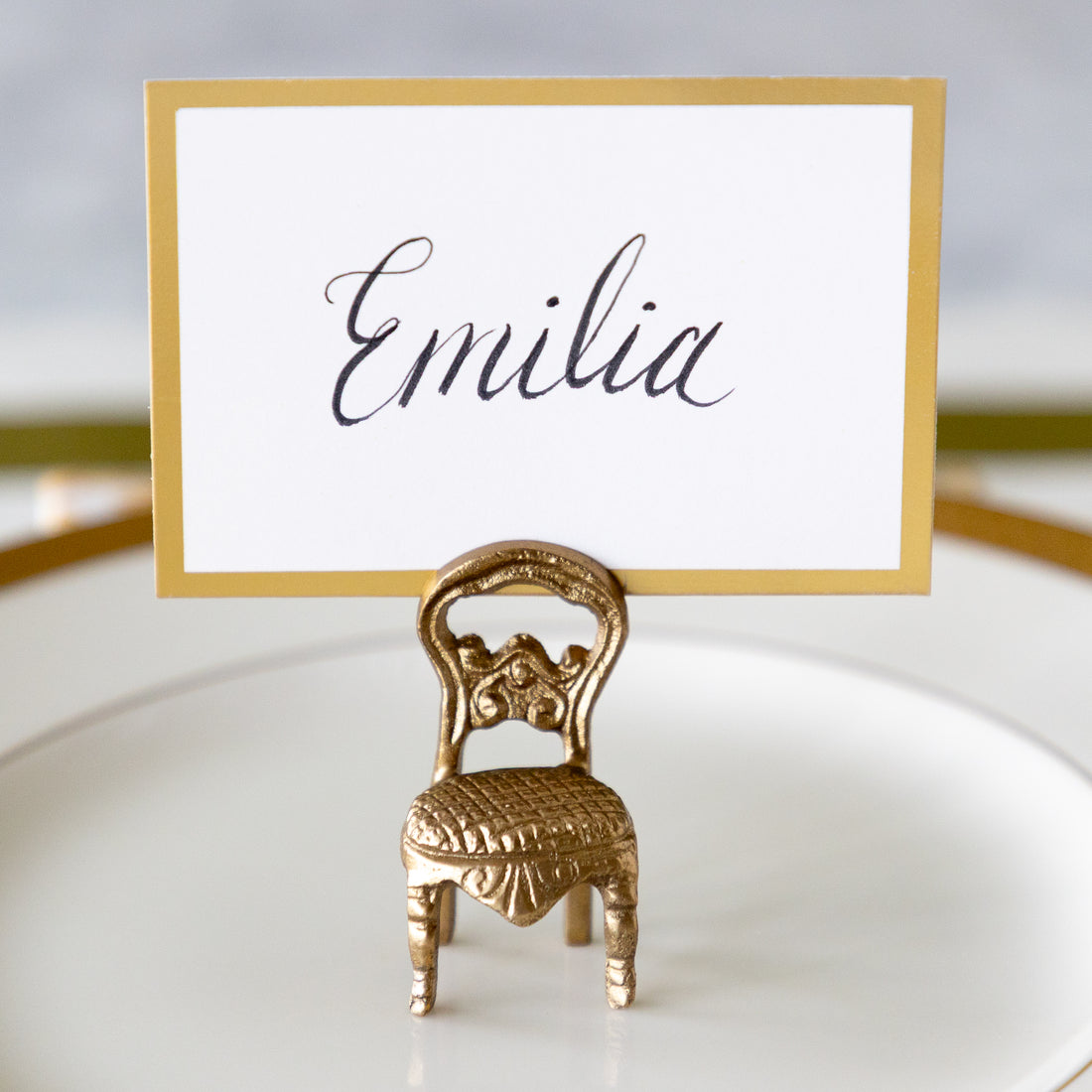 A gold-framed place card with the name &