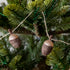 Close up of woolen acorn garland in a tree showing its glittered top .