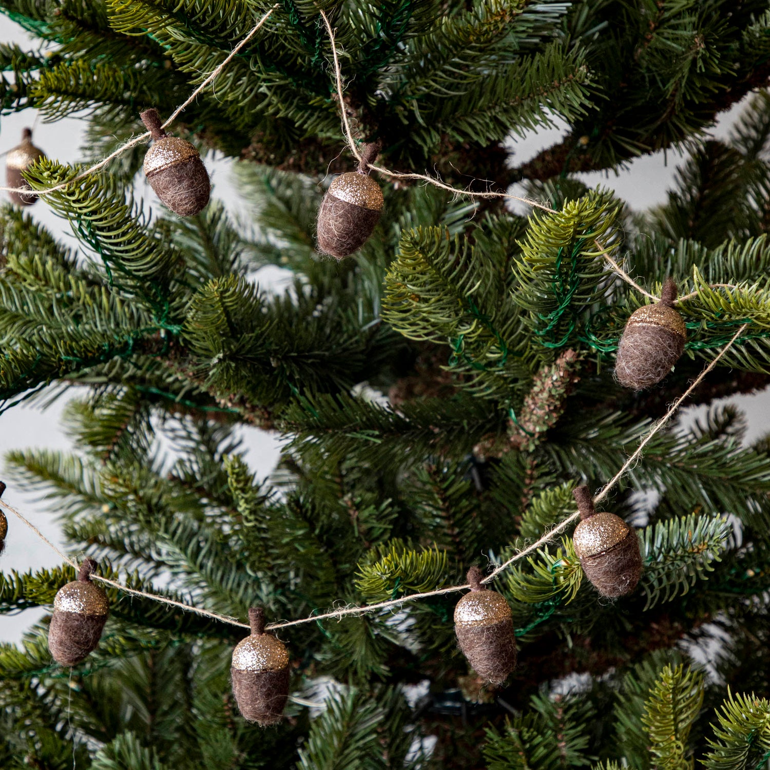 Woolen acorn garland strewn around a tree.