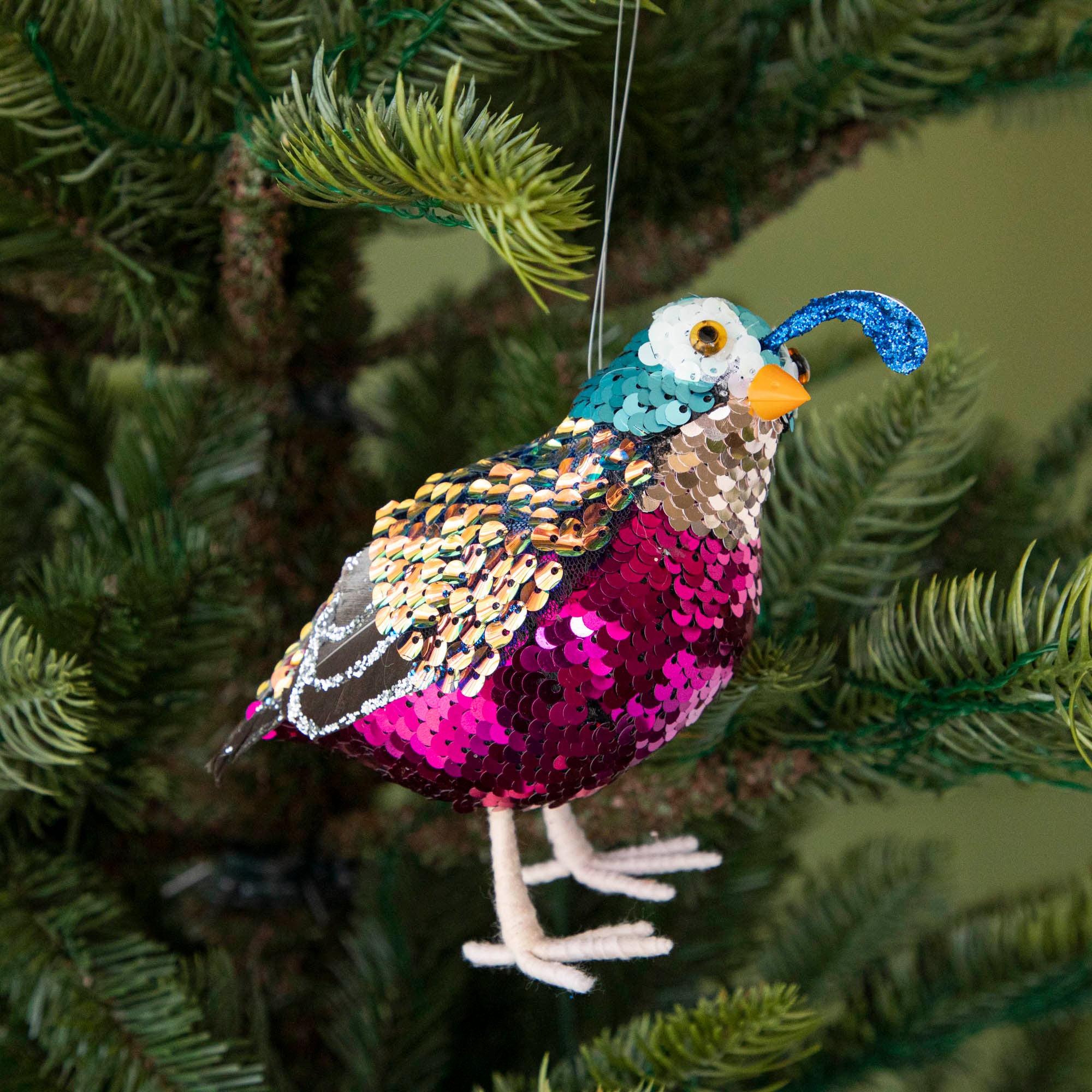 Sequin quail hanging in a tree.