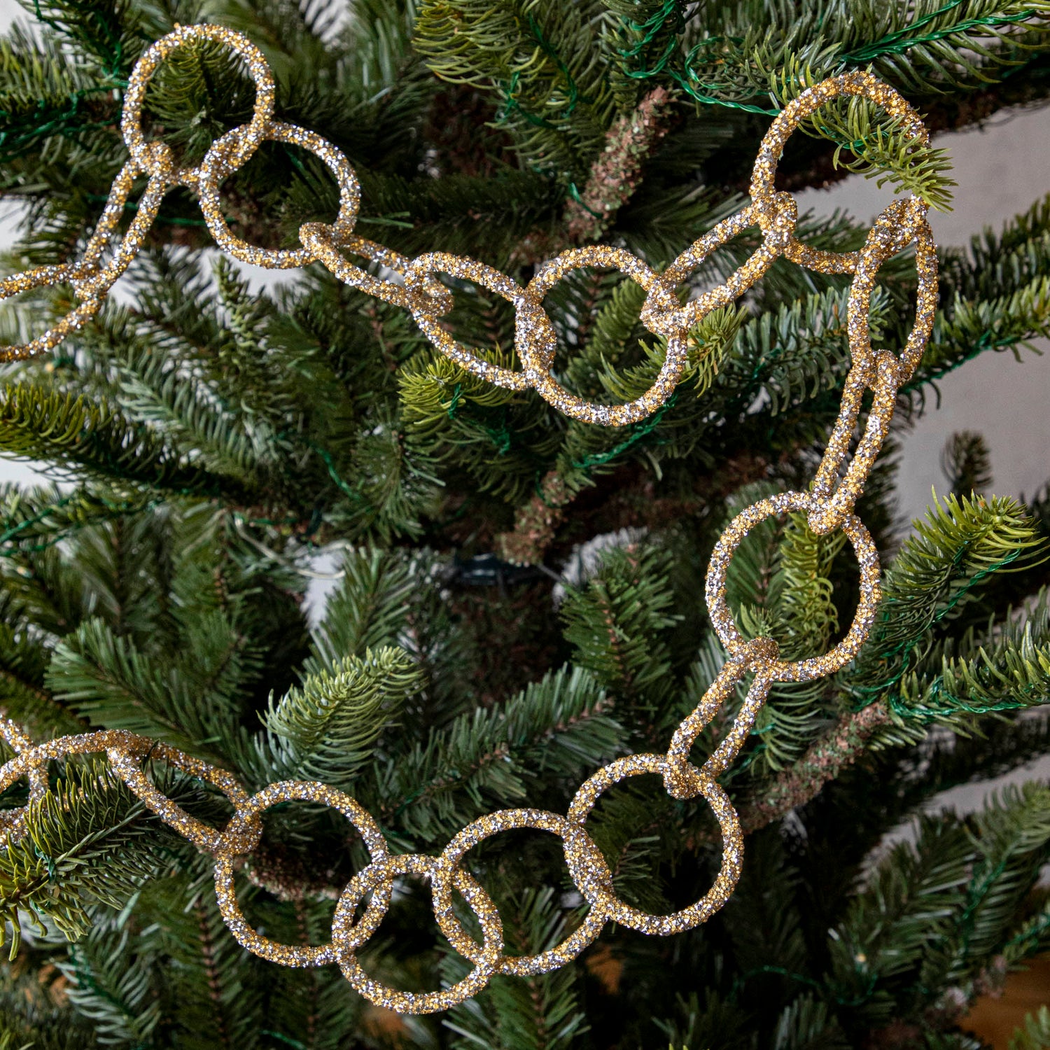 Gold &amp; silver sparkly ring garland hanging in tree.