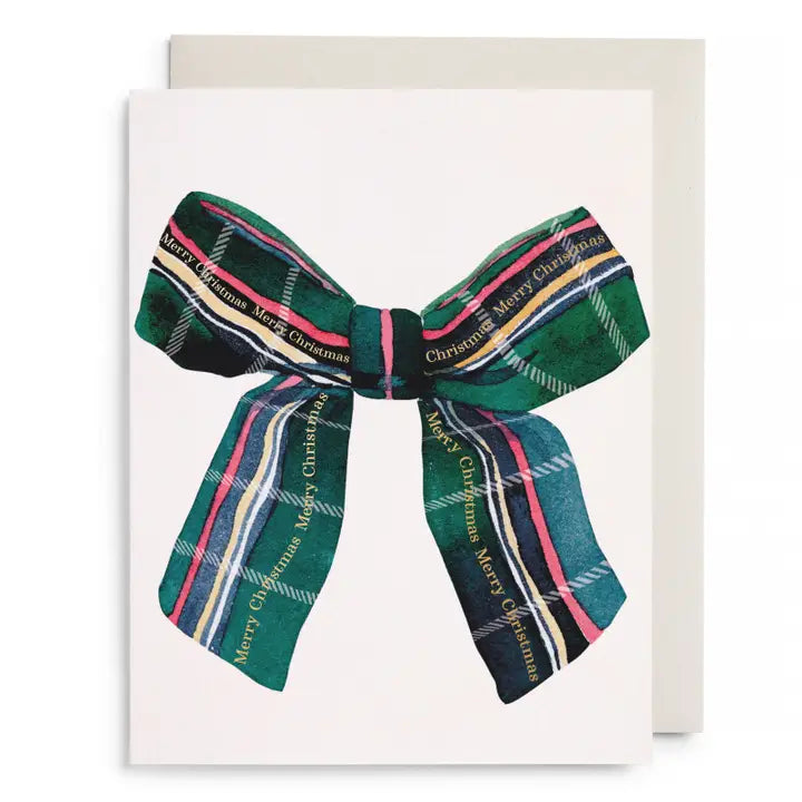 A Christmas greeting card featuring a large plaid ribbon bow in green, navy, pink, yellow, and white with &