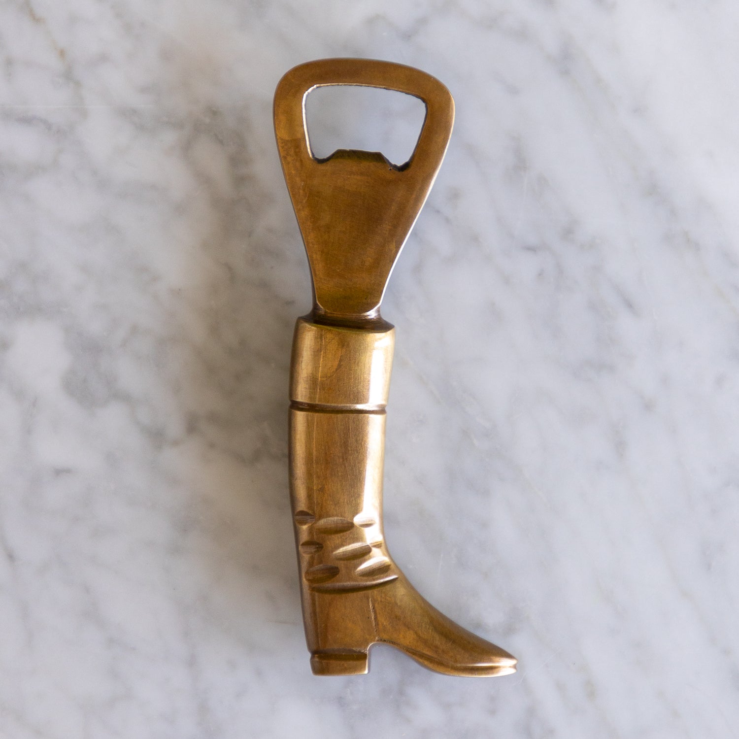A brass bottle opener shaped like a boot.
