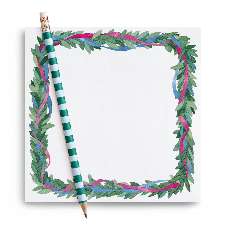 Pencil with striped design on a notepad with green leaf border