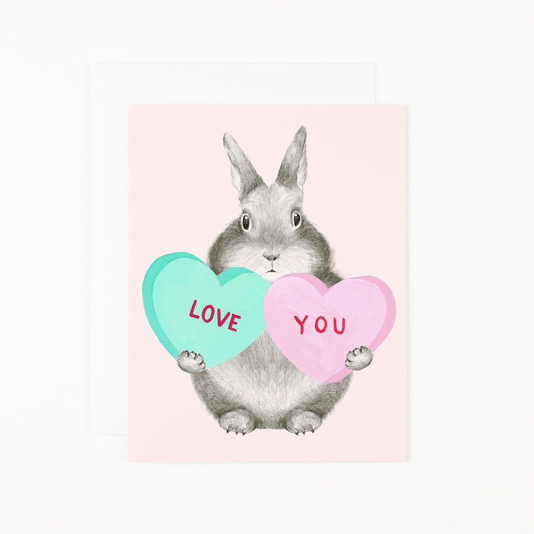 Illustration of a rabbit holding heart-shaped &