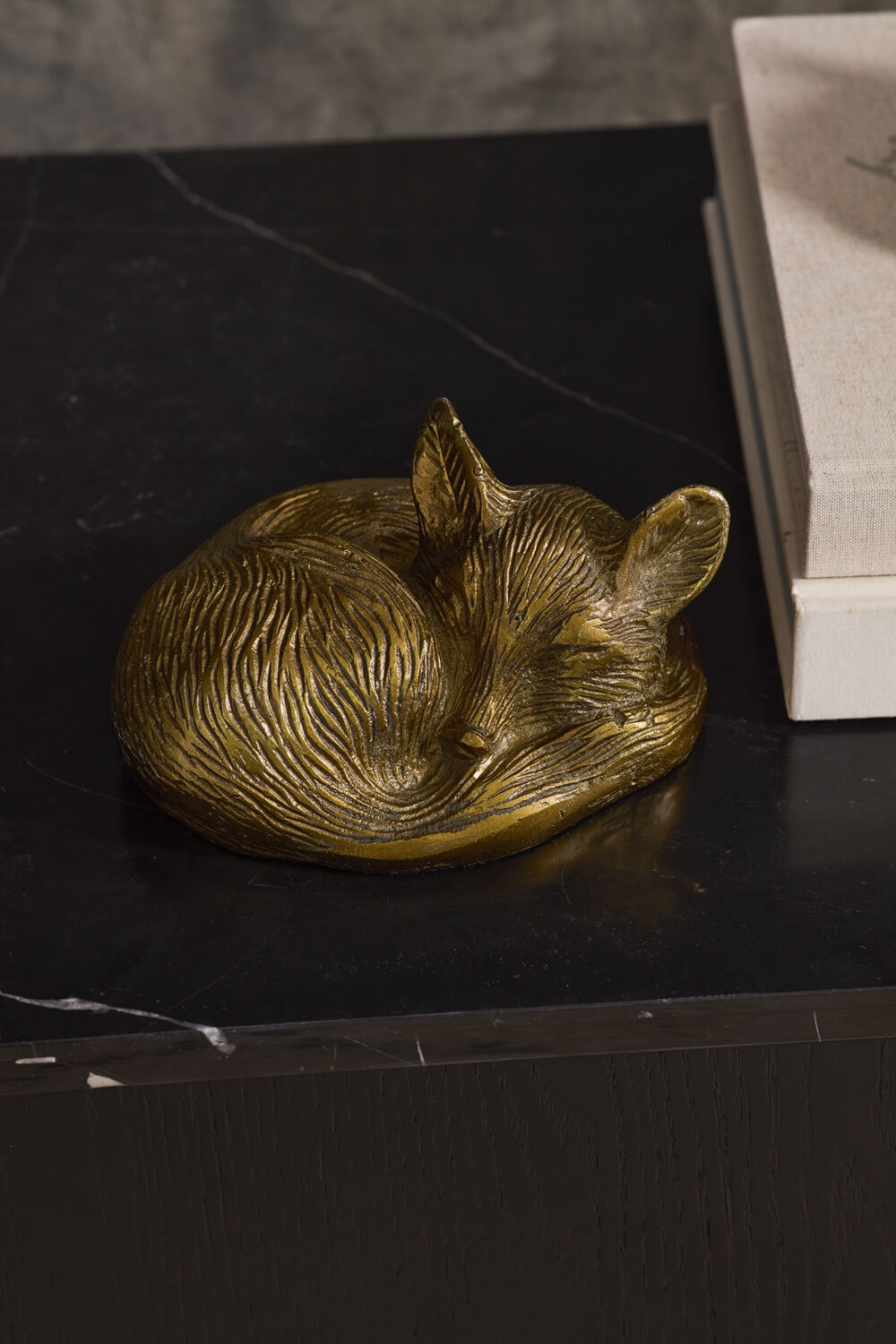 Gold fox-shaped object on a dark surface.