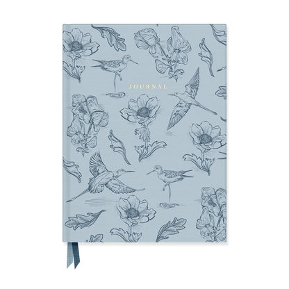 Blue notebook with various birds and flower illustrations on it with Journal printed in the middle at the top