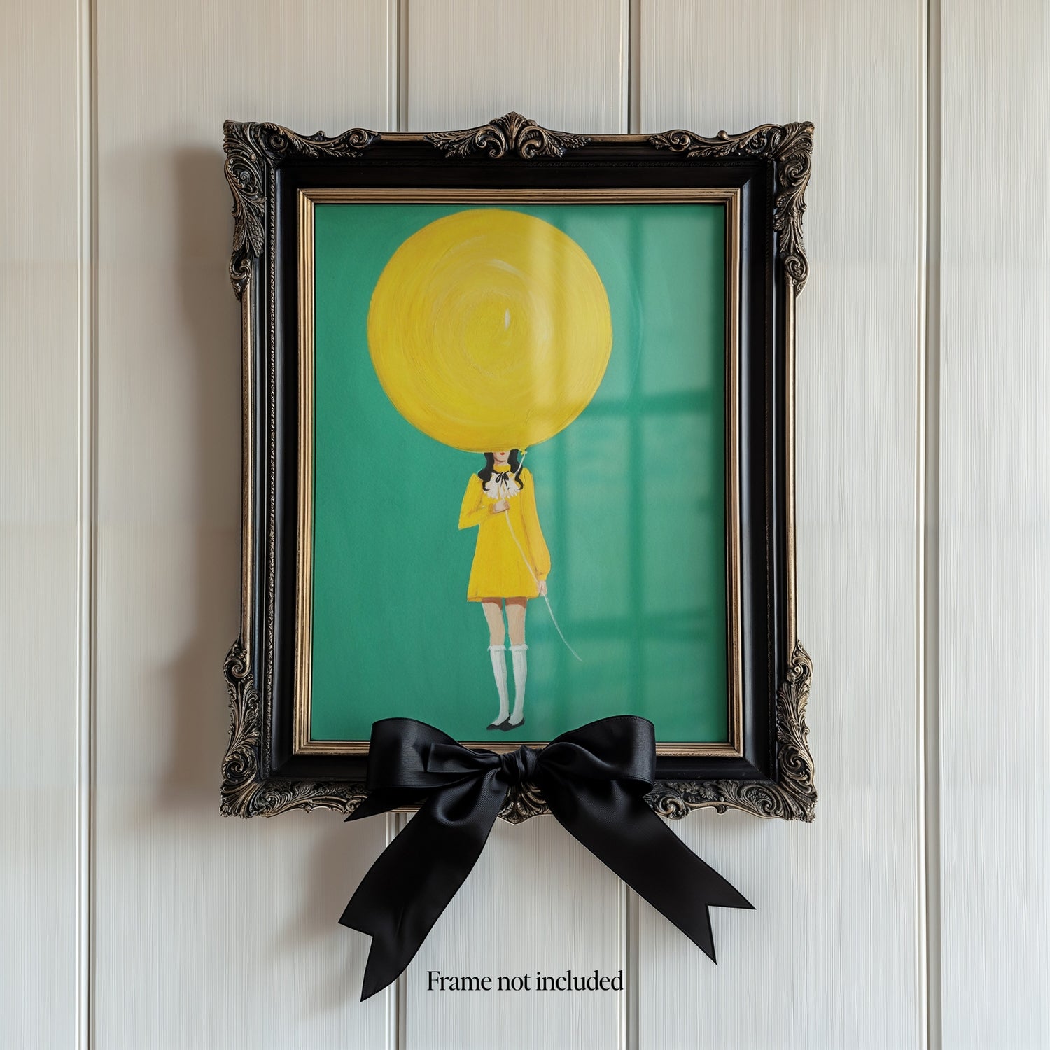 Janet Hill artwork featuring a girl wearing a yellow dress holding a large yellow balloon shown in a black frame. 